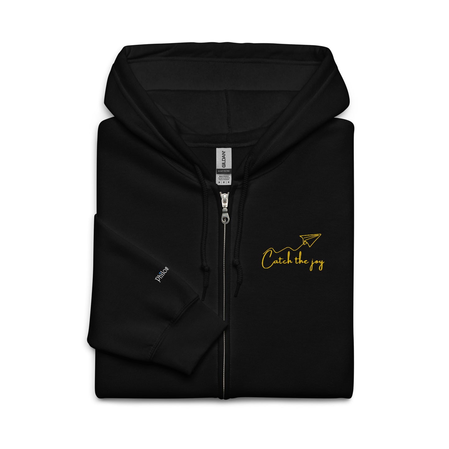 Black unisex cotton zipped hoodie with “Catch the Joy” embroidery and origami plane design — soft, minimal, relaxed fit.