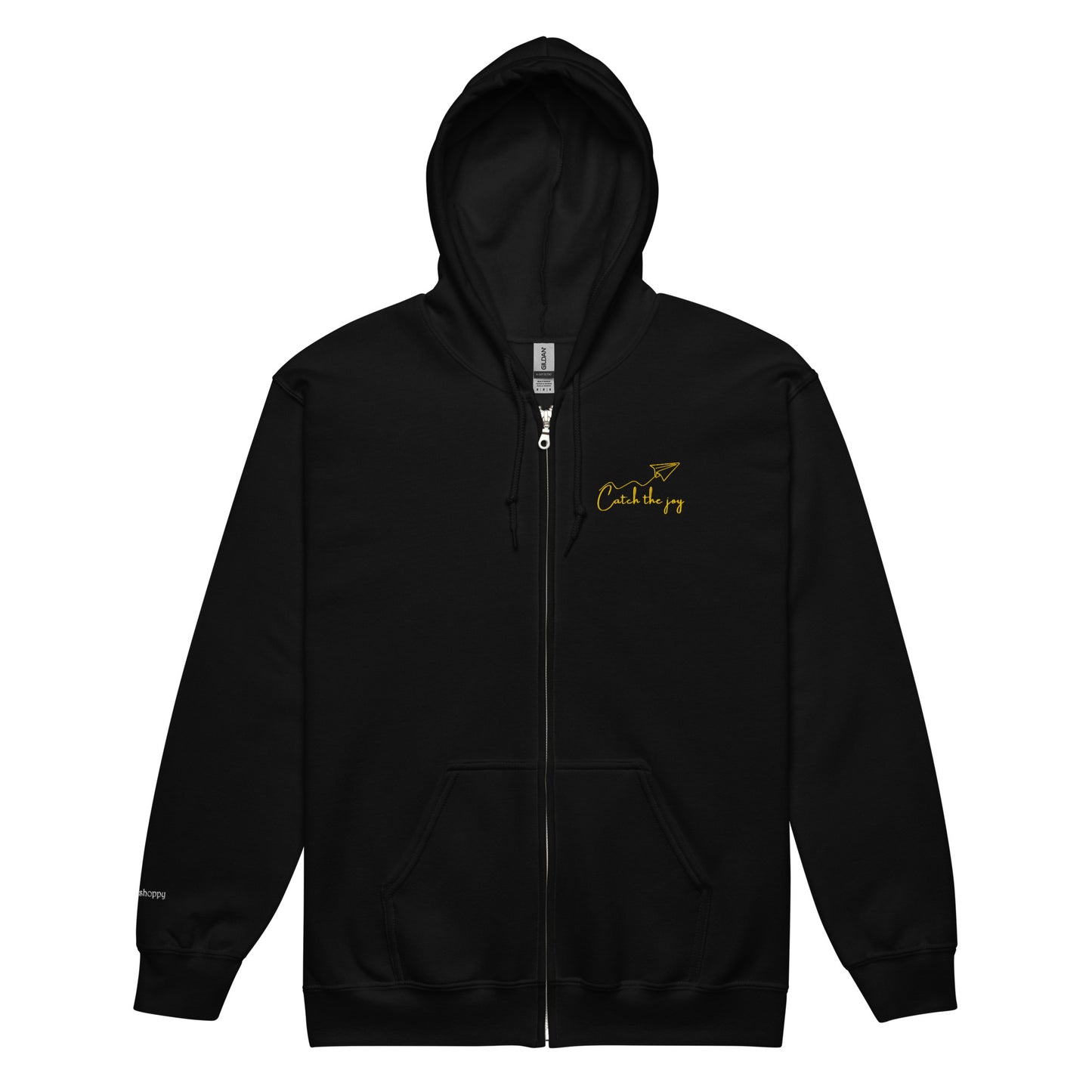 Black unisex cotton zipped hoodie with “Catch the Joy” embroidery and origami plane design, soft, minimal, relaxed fit.