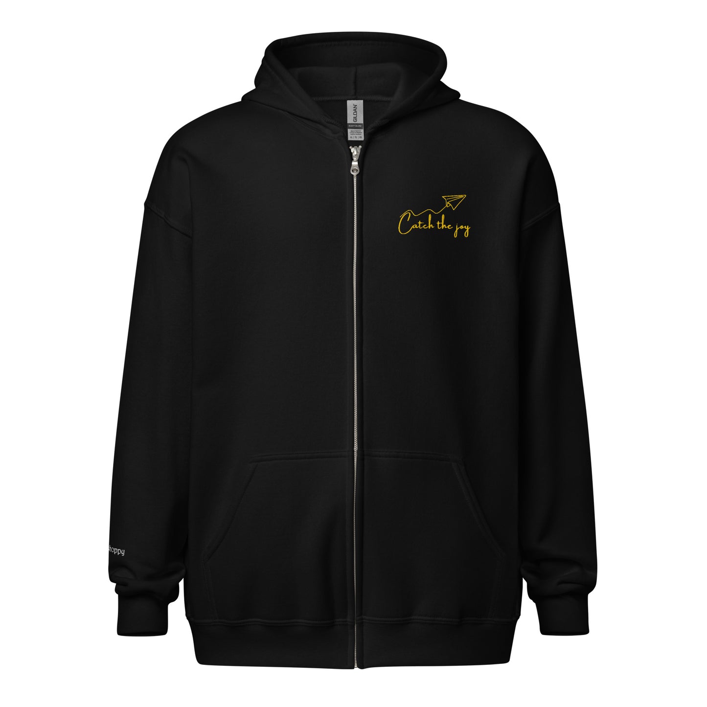 Black unisex cotton zipped hoodie featuring “Catch the Joy” embroidery with an origami plane, a wearable reminder to stay open to small moments of happiness as they drift your way.