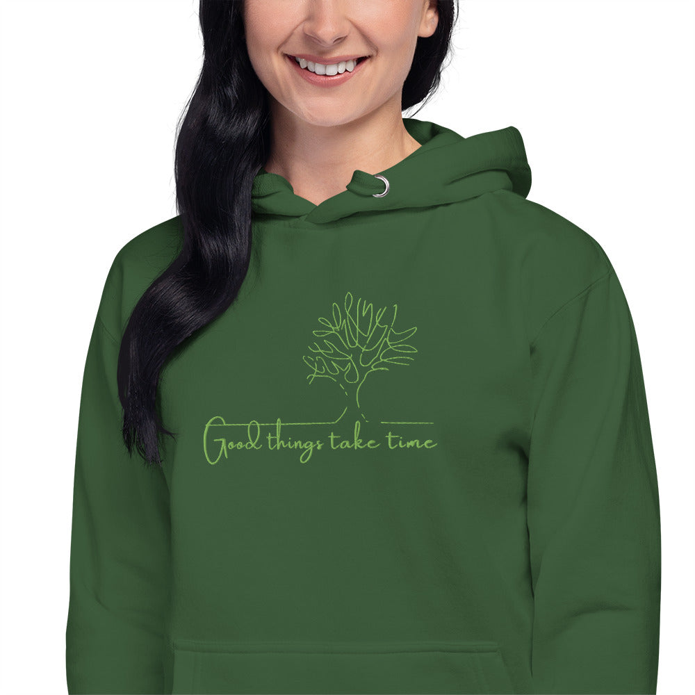 Relaxed green hoodie with “Good Things Take Time” text, unisex design symbolizing patience, growth, and mindful living.