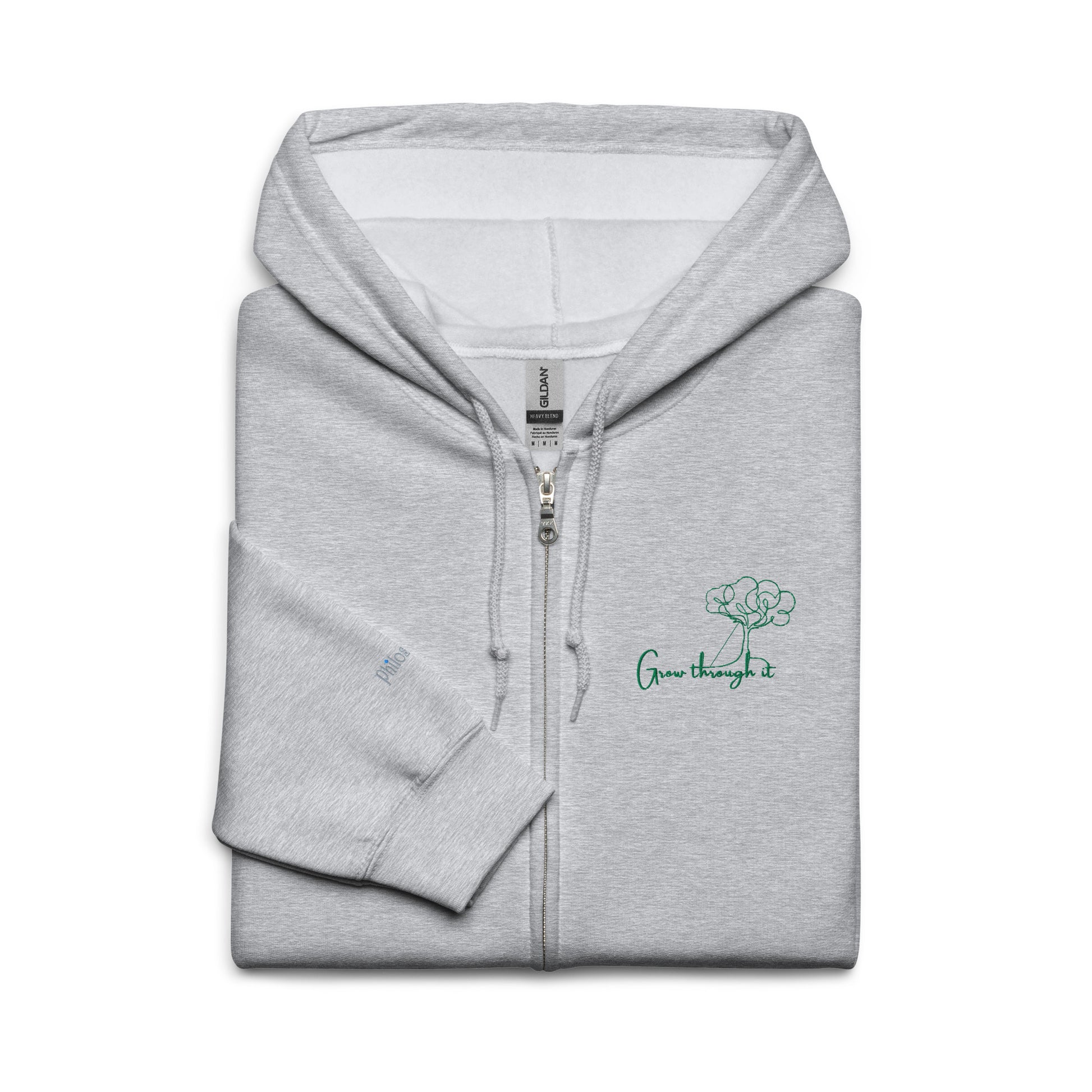 Grey unisex cotton zipped hoodie featuring “Grow Through It” embroidery with a minimalist tree, a gentle reminder that every challenge holds the seed of growth.