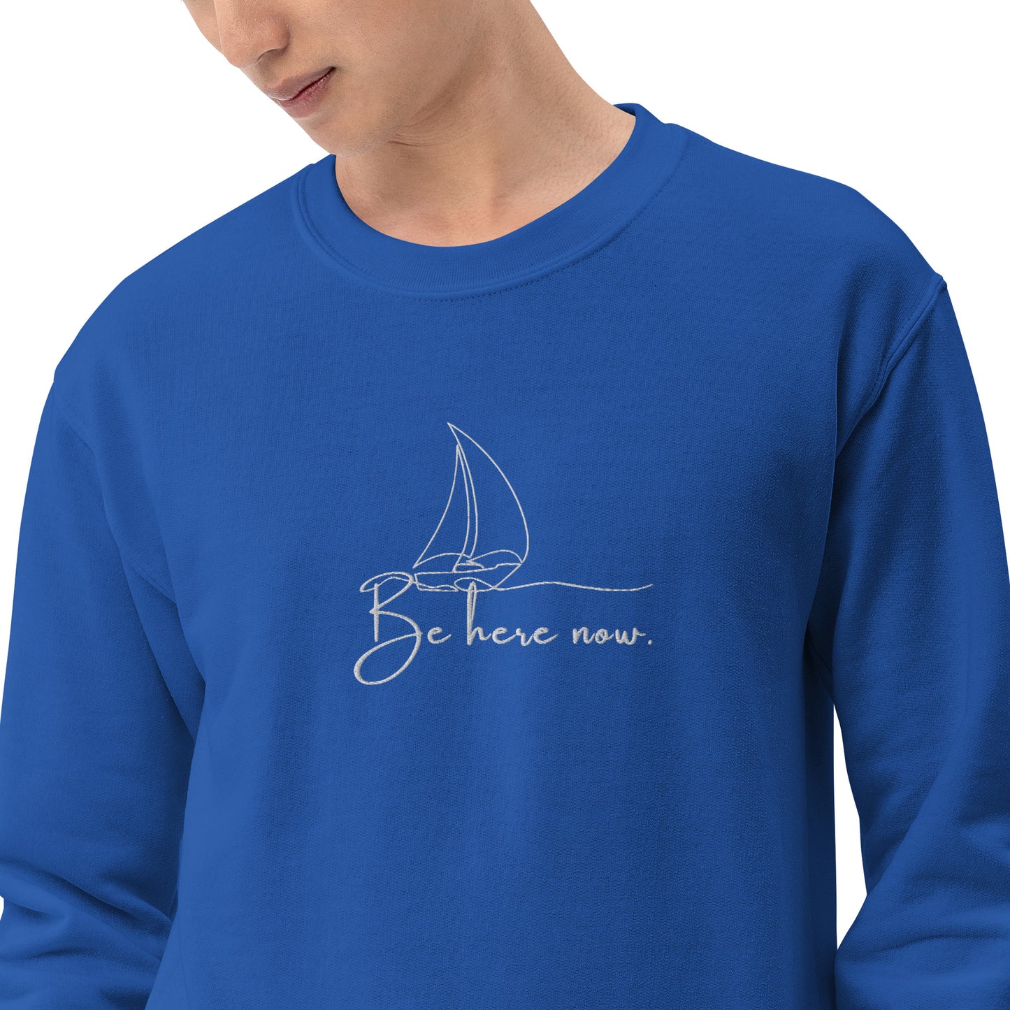 Royal blue embroidered sweatshirt with “Be Here Now” and simple sailing boat design, unisex design celebrating presence, mindfulness, and calm.