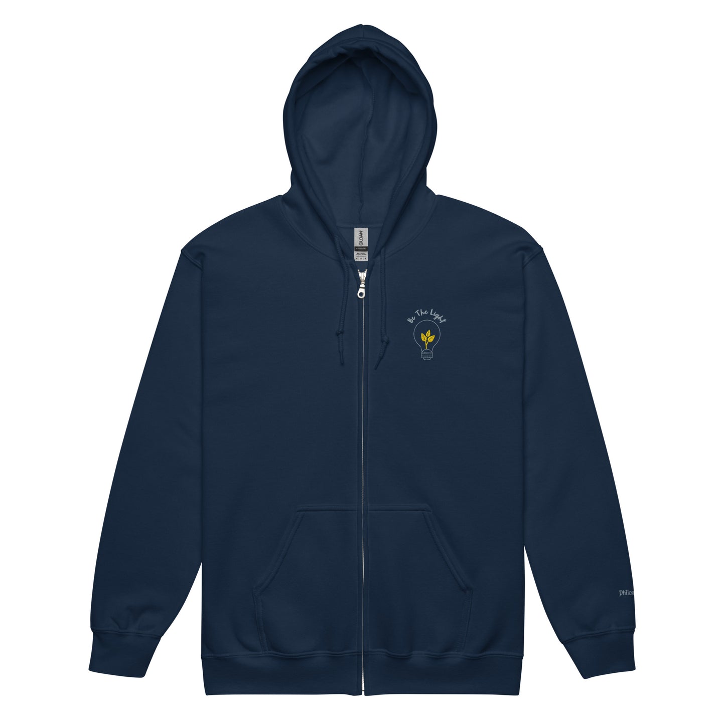 Navy blue unisex cotton zipped hoodie featuring “Be the Light” embroidery with a bulb and plant, a wearable reminder to grow gently and illuminate the world with your presence.