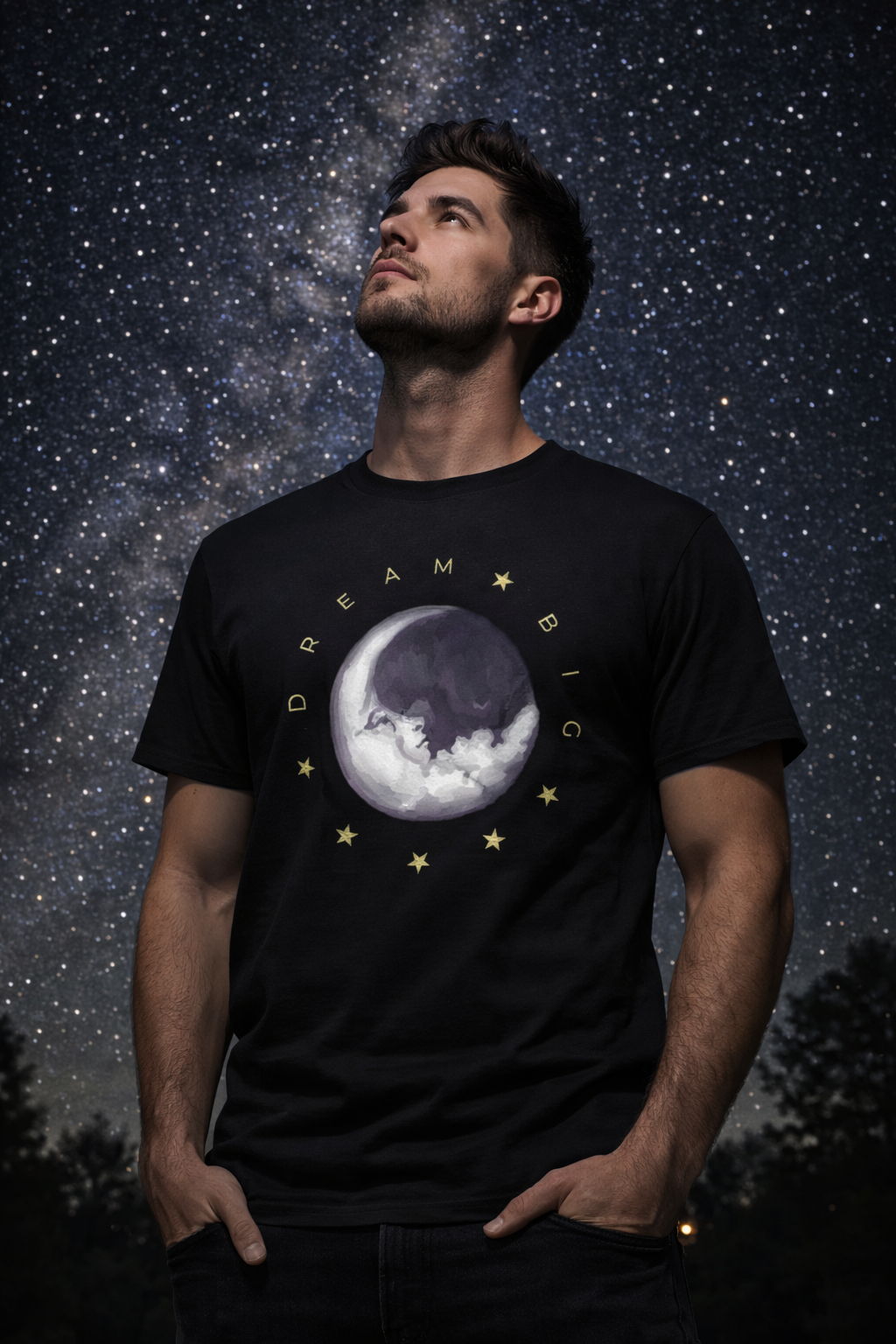 Man wearing a black t-shirt with a moon and star design against a starry night sky.