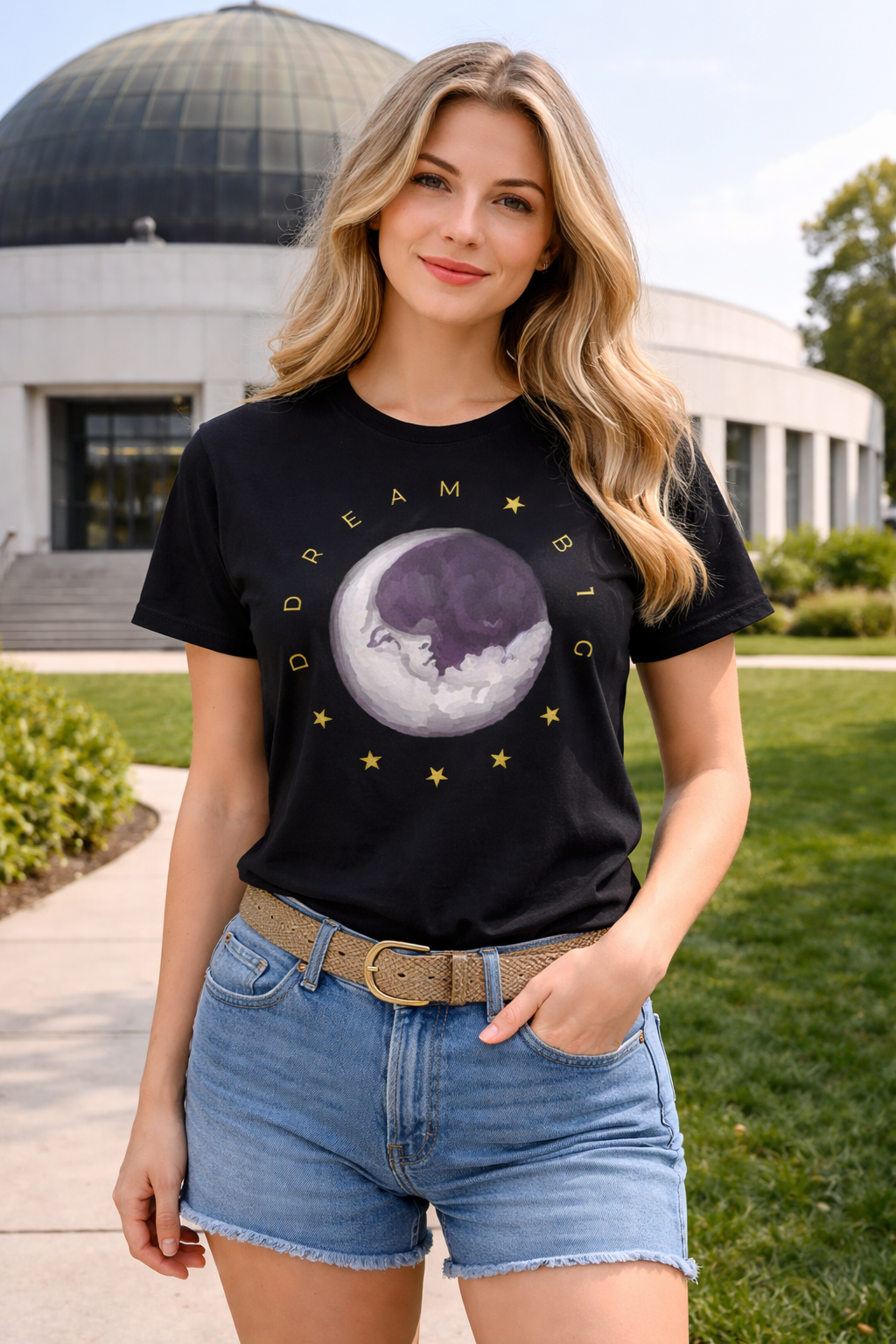 Woman wearing a black t-shirt with a moon and star design, standing outdoors.