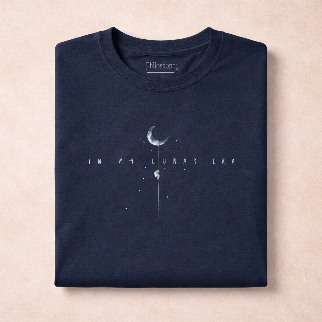 Navy blue t-shirt with moon graphic and text 'In my lunar era' on a beige background