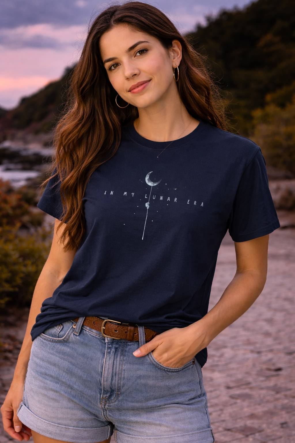 Woman wearing a navy blue t-shirt with a  astronaut climbing moon graphic with starry sky and "I'm in my Lunar Era" text