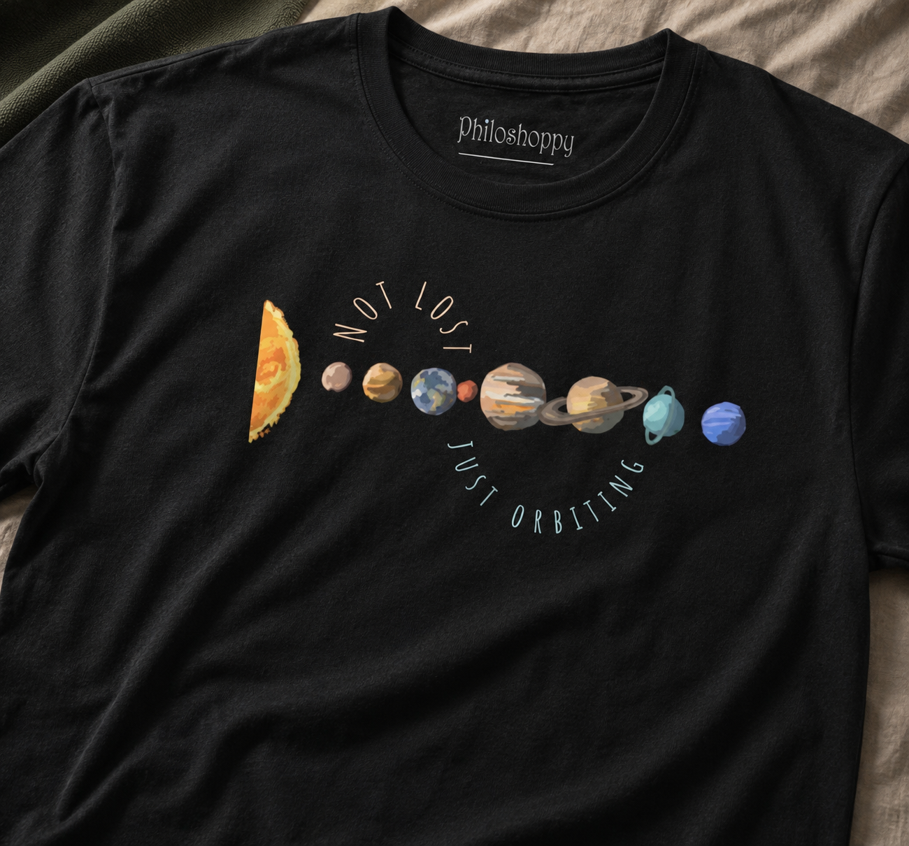Black t-shirt with solar system design and 'Philosoppy' branding on a textured surface.