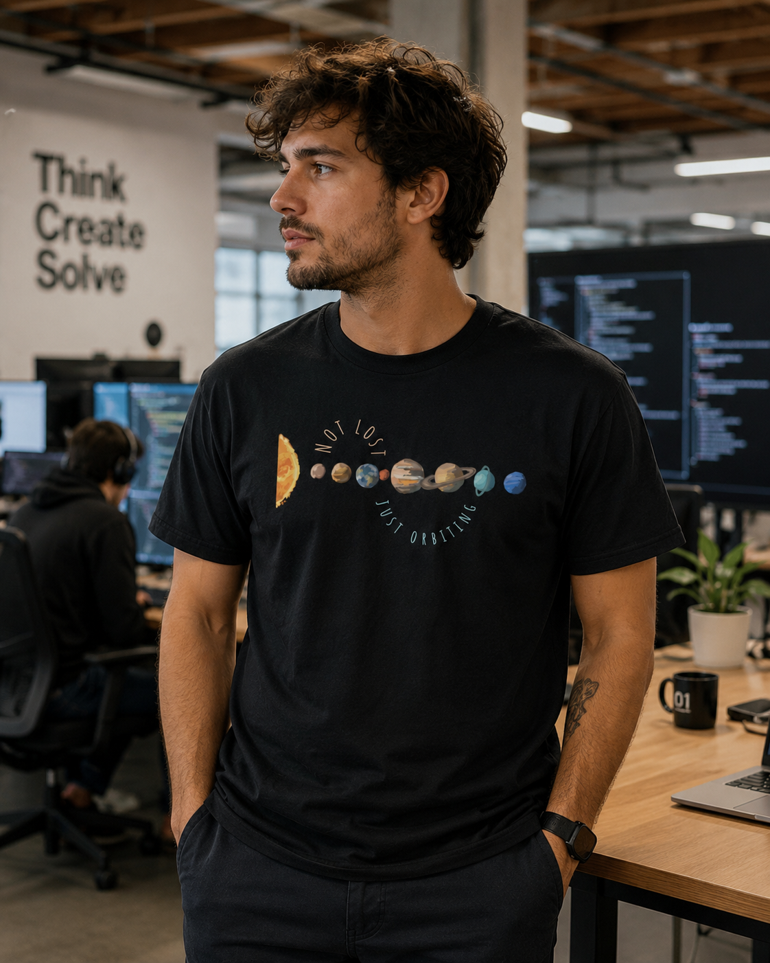 Man wearing Not Lost Just Orbiting astronomy graphic t-shirt in casual everyday styling in an office setting.