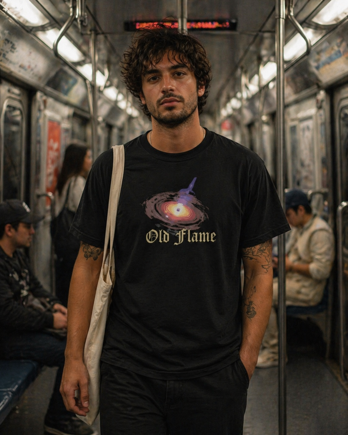 Man wearing a black t-shirt with 'Old Flame' design on a subway train.