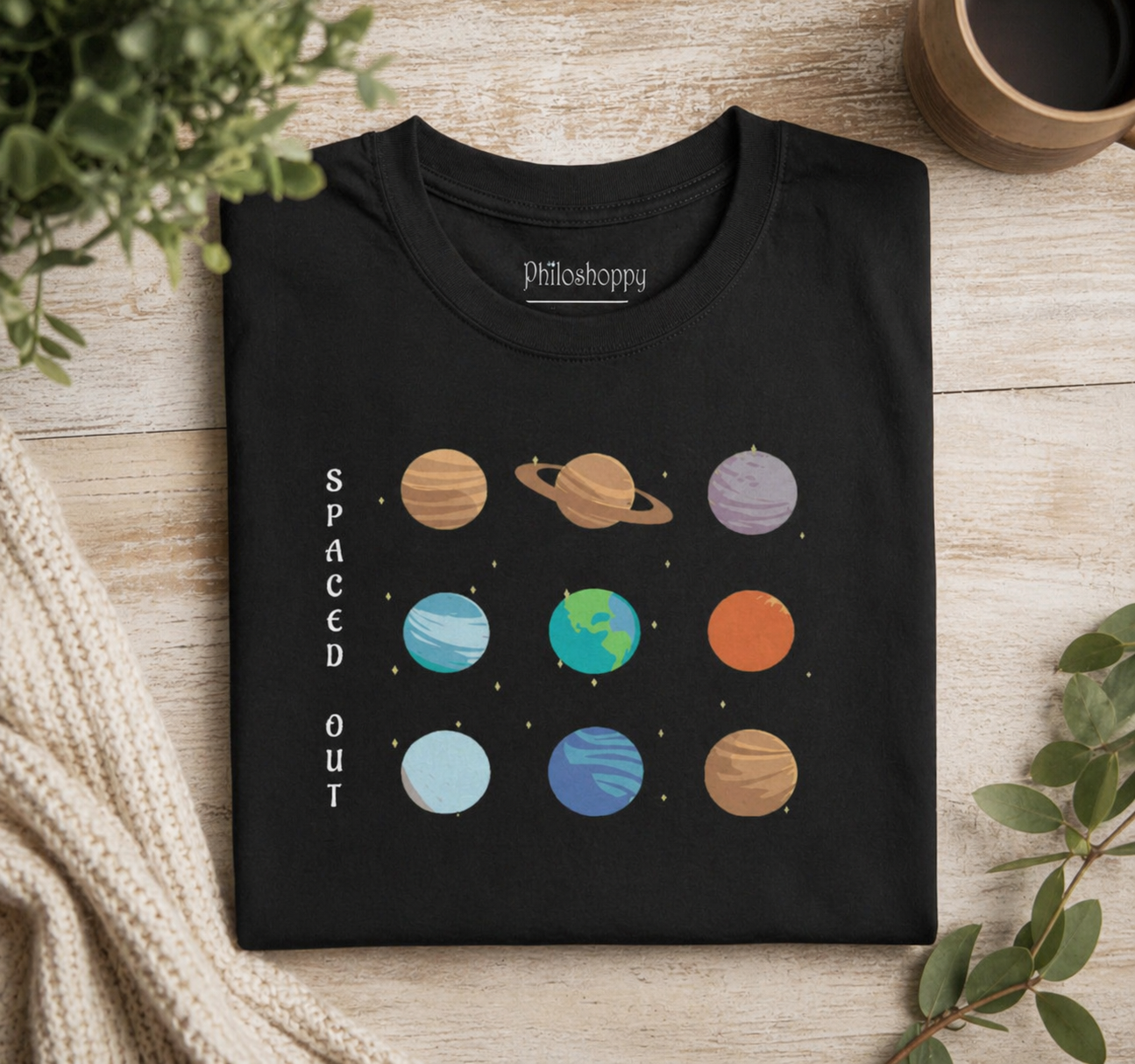 Black unisex cotton t-shirt with solar system design on a wooden surface
