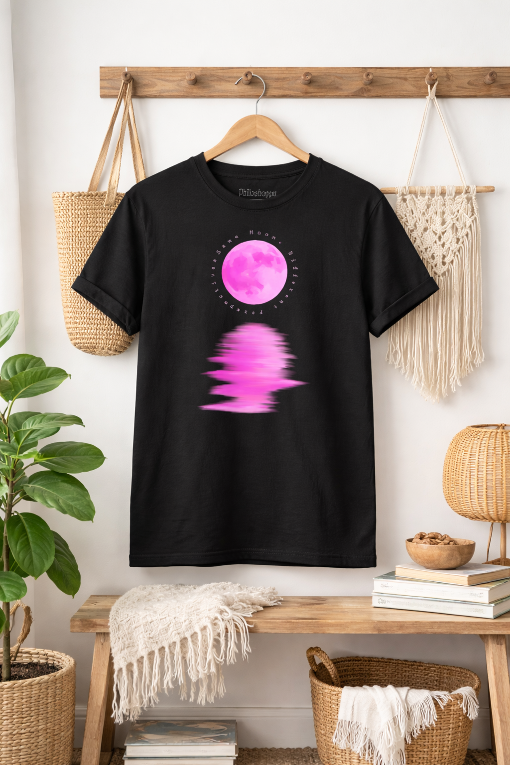 Black cosmic t-shirt hanging on rack showing moon reflection graphic on front 