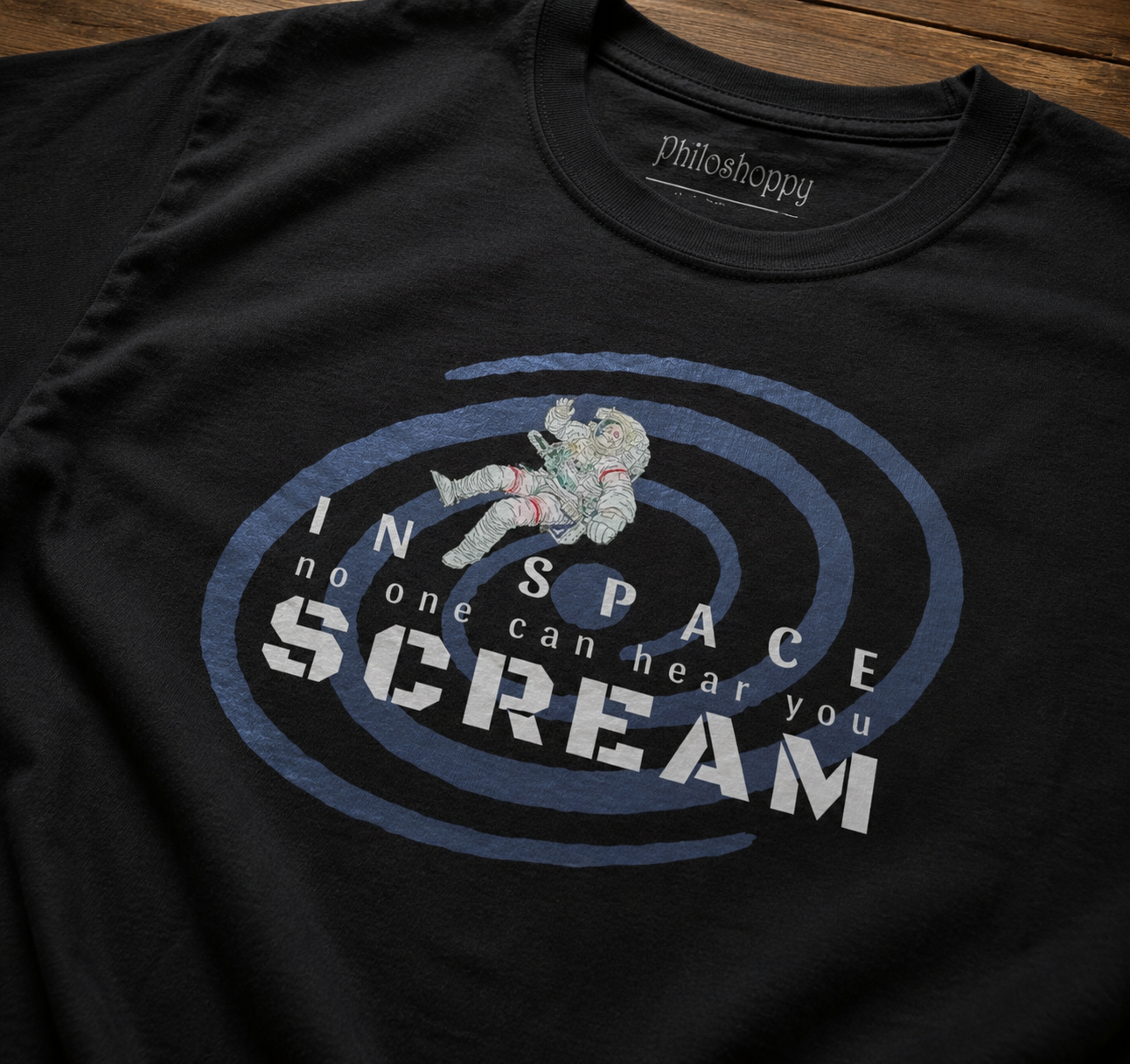 Black t-shirt with 'In Space No One Can Hear You Scream' graphic design on a wooden surface.