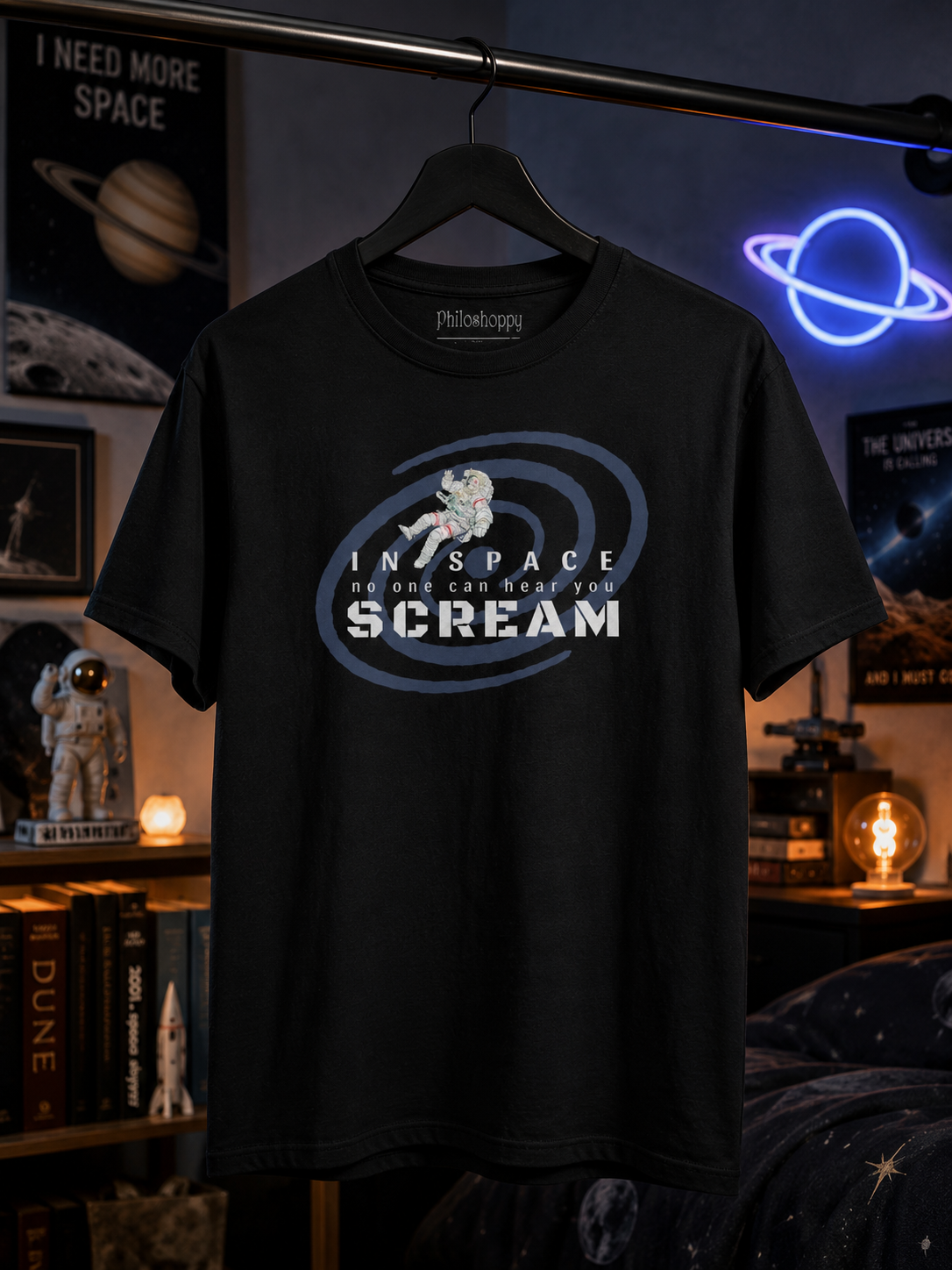 Black t-shirt with 'In Space No One Can Hear You Scream' design on a hanger against a space-themed room background.