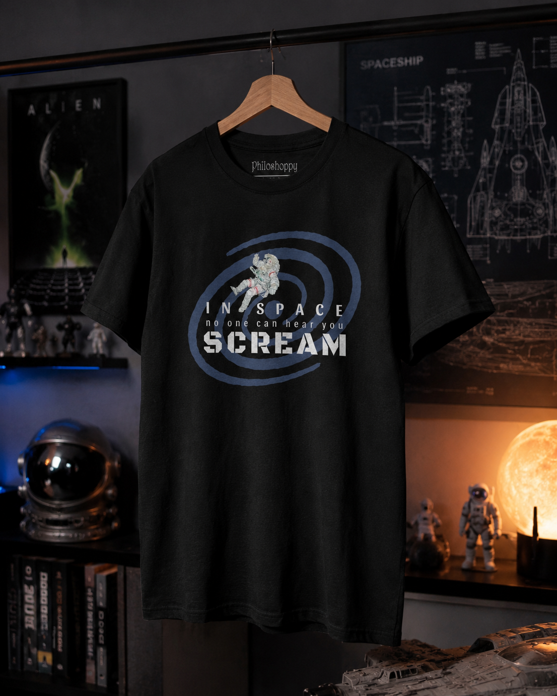Black t-shirt with 'In Space No One Can Hear You Scream' design on a hanger against a dark background with posters and models.
