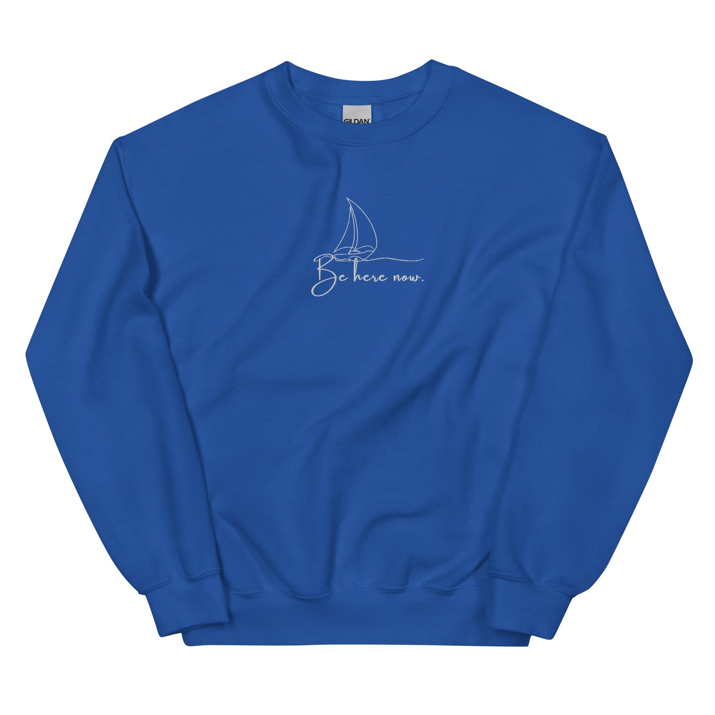 Royal blue embroidered sweatshirt with “Be Here Now” and simple sailing boat design, unisex design celebrating presence, mindfulness, and calm.