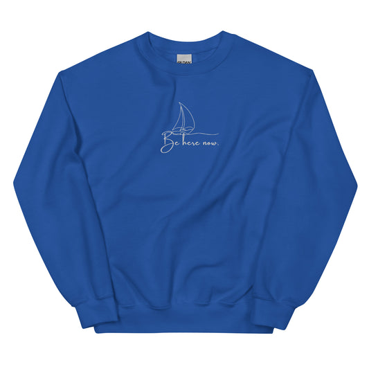 Royal blue embroidered sweatshirt with “Be Here Now” and simple sailing boat design, unisex design celebrating presence, mindfulness, and calm.