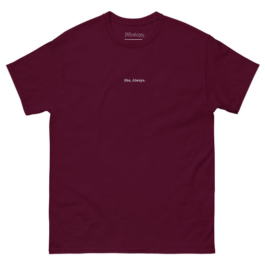 Front view of maroon unisex cotton T-shirt with “She. Always.” bold text print.