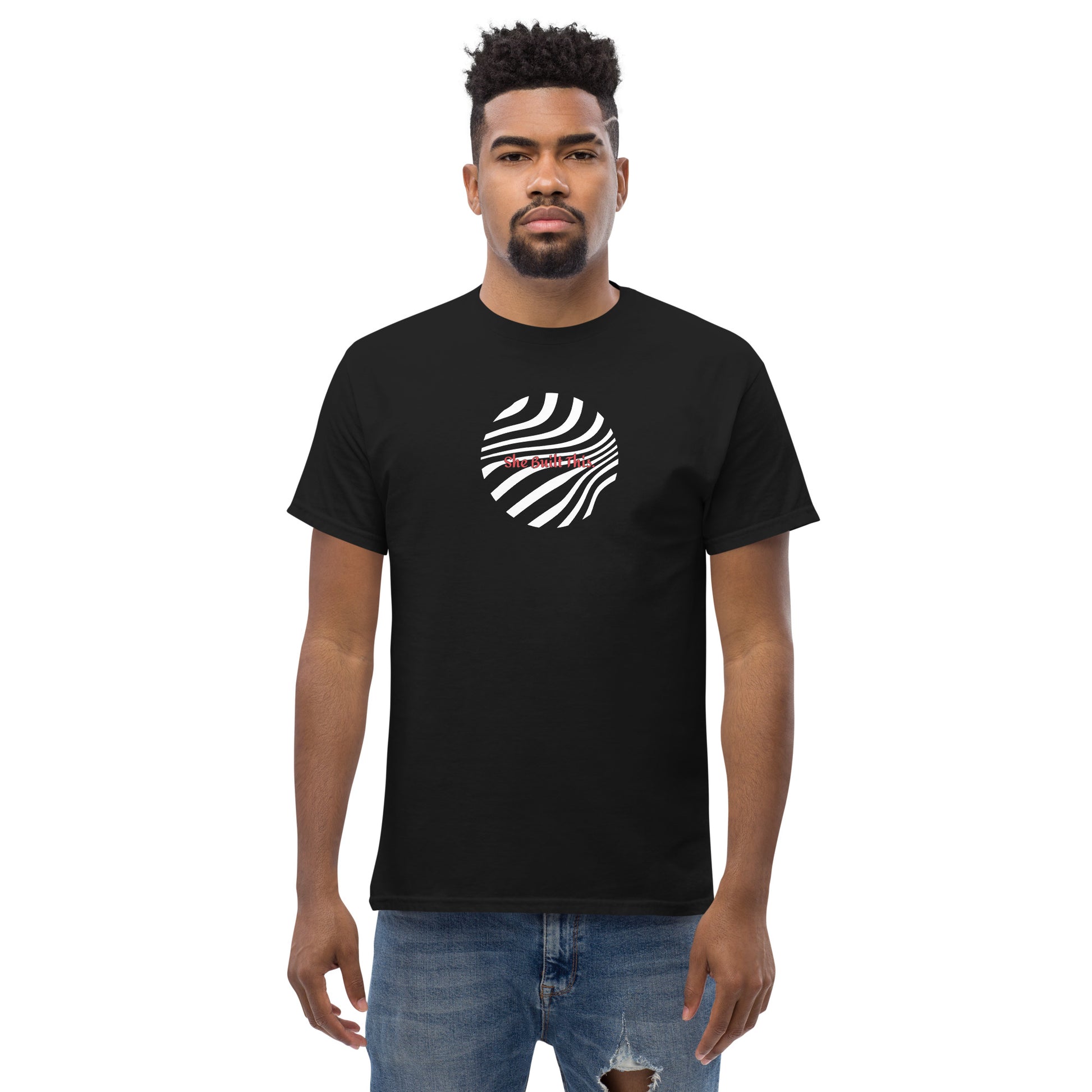 Male model wearing black “She Built This” unisex T-shirt with minimal design, showing support for women’s empowerment.
