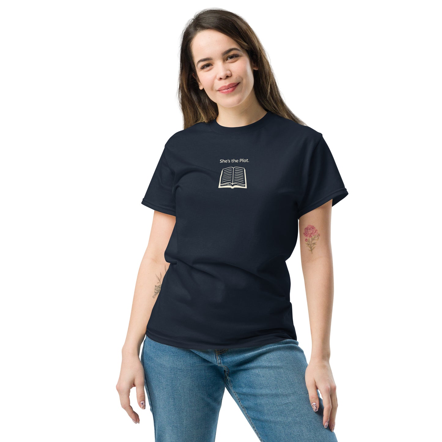 Female model wearing navy “She’s the Plot” unisex T-shirt with book illustration, celebrating women’s stories and leadership.