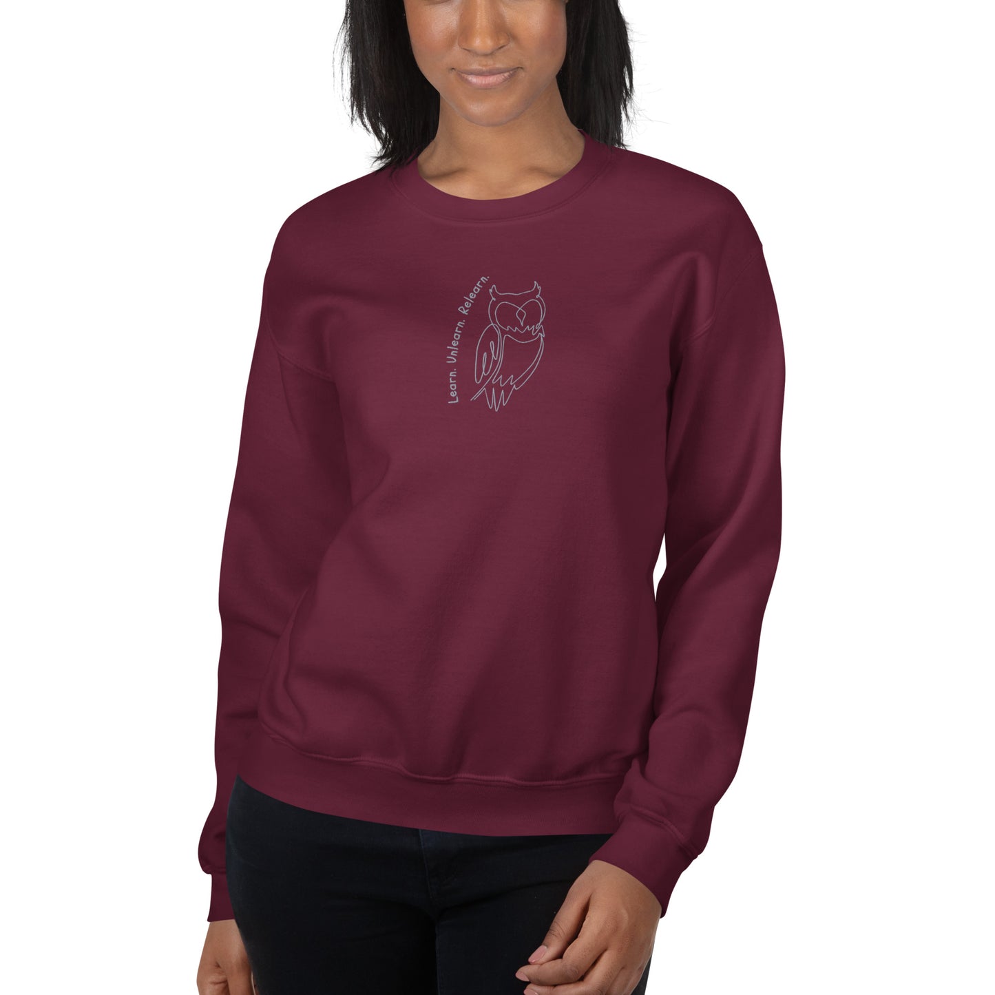 Maroon embroidered sweatshirt with Learn. Unlearn. Relearn. text and minimal owl motif, unisex design celebrating wisdom, reflection, and growth.