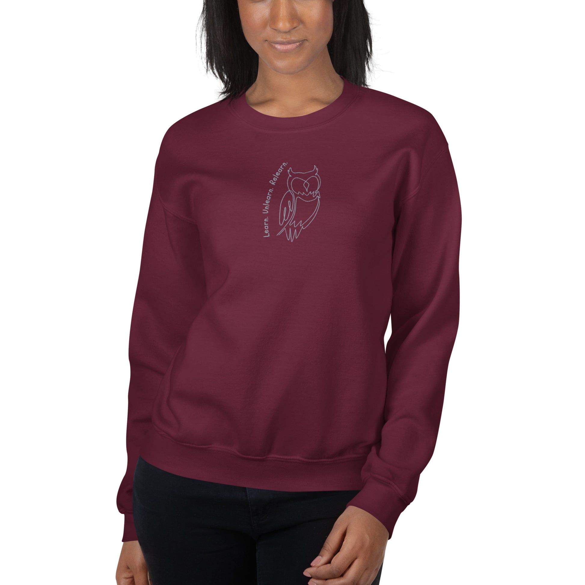 Maroon embroidered sweatshirt with Learn. Unlearn. Relearn. text and minimal owl motif, unisex design celebrating wisdom, reflection, and growth.